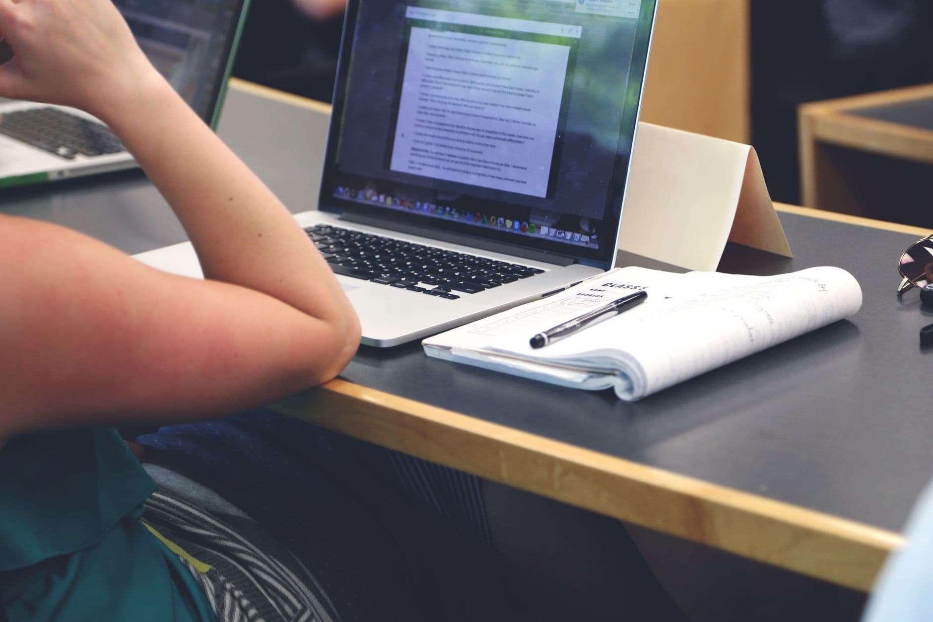 Elev pluggar körkortsteori på laptop med anteckningar inför teoriprovet.
